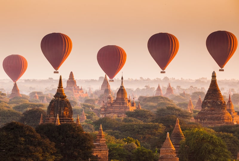 Ein bunter Heißluftballon schwebt über der historischen Ebene von Bagan in Myanmar